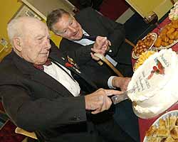Henry Allingham cuts a celebratory cake at the ceremony.
